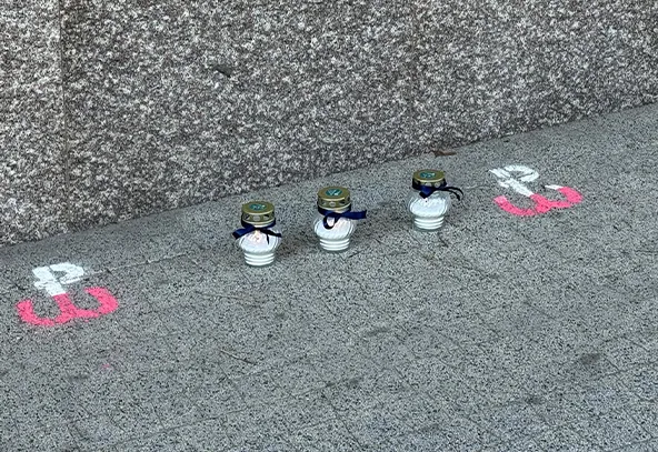 Trzy znicze ustawione na chodniku przy murze, z obu stron namalowane symbole Polski Walczącej w białym i czerwonym kolorze.